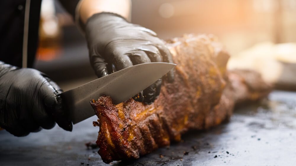 A person cutting ribs at one of the restaurants in Idabel.