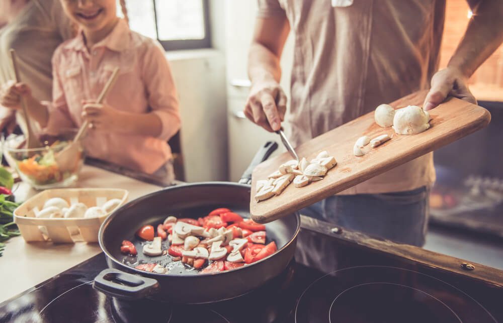 A family cooking winter recipes in their Hochatown cabin rental.