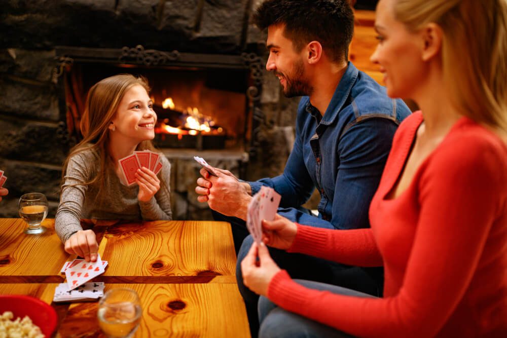 A family playing a card game in a cabin in Broken Bow.